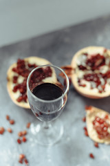 A wine glass with red wine stands on a gray grunge background next to grenades.