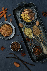 Spices for baking gingerbread, muffins or mulled wine - vanilla, cinnamon, coriander, cloves cardamom fennel nutmeg on grey background
