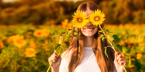 Summer portrait. Happy joyful girl with sunflower enjoying nature and laughing on sunflower field
