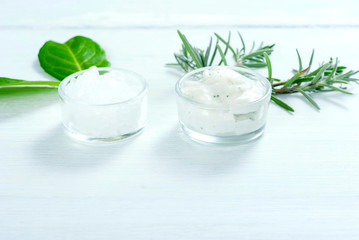 cosmetic cream and bath salt on white wooden table
