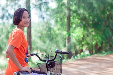 portriat asian cute children on bicycle. lettle girl smilling and fun in park at thailand