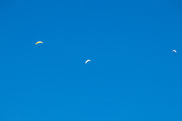 View of three paragliders in the swiss alps