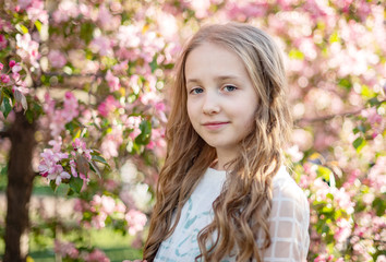 candid portrait of a girl in a blooming apple orchard