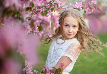 Fototapeta premium candid portrait of a girl in a blooming apple orchard