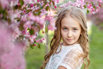 Fototapeta premium candid portrait of a girl in a blooming apple orchard