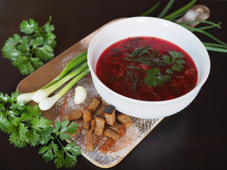 Delicious and healthy traditional soup borscht with grass in a white plate. 
