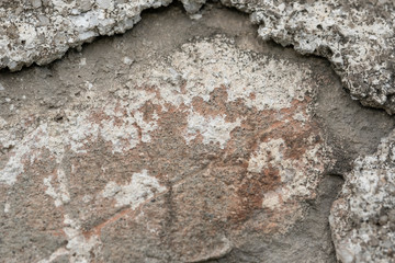 Concrete area with jagged edges. Different levels of height. Red spot, stone crumb. 