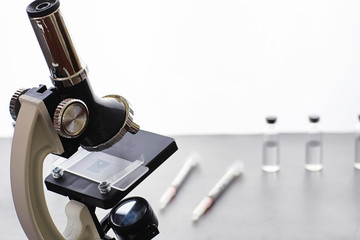 Research laboratory. Test tubes and microscope on the table on a white background.