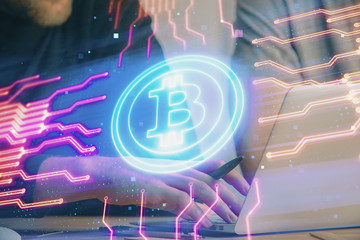 Crypto currency theme hologram with businessman working on computer on background. Concept of...