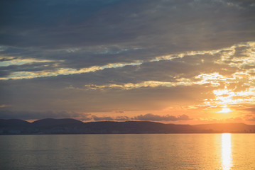 sunset over Novorossiysk city of Russia, Black sea twilight, view from sea, horizontal panoramic stock photo image