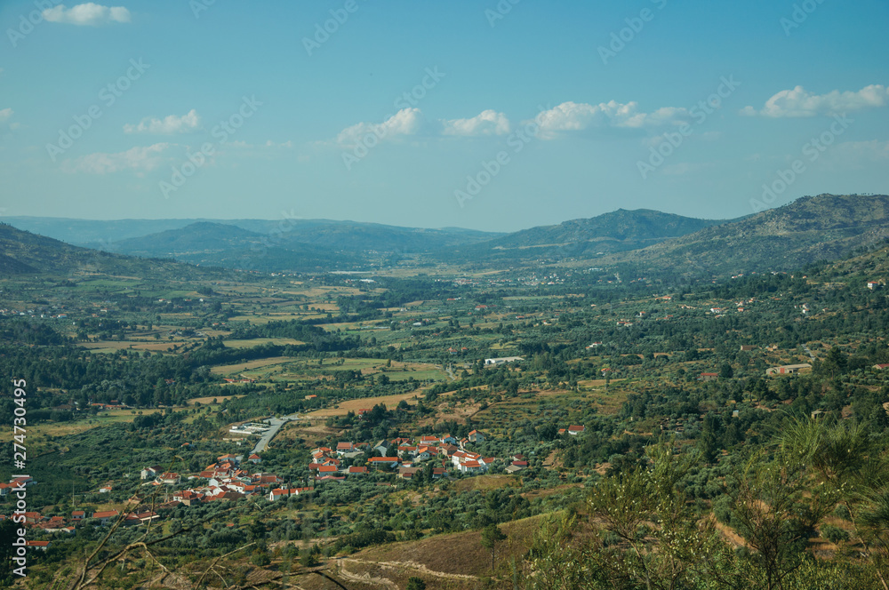 Wall mural Valley with the roofs of a small village underneath