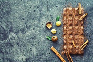 A bar of milk chocolate on the table. Chocolate with nuts and cinnamon.