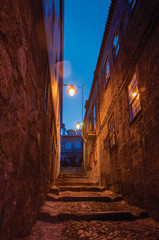 Alley with steps and stone houses at night