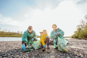 Friendly family organized cleaning day to clean  place near lake  of household garbage..