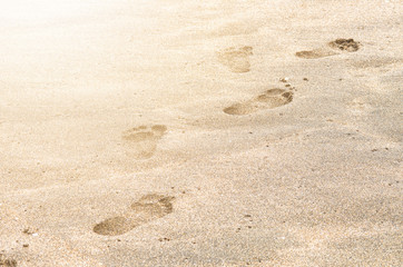 Footprints in the sand on sea coast. Vacation concept