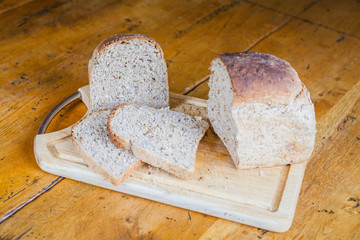sliced granary bread loaf on chopping board