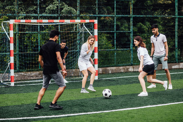 Portrait of male and female, adult  soccer teams playing together on field.