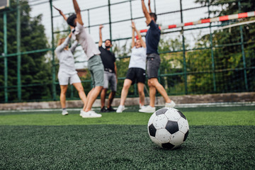 It is time for football..Close up of football ball  on green field.. Players going  to playing together..