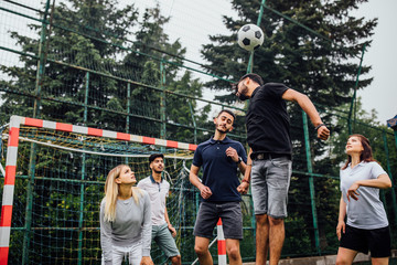 Happy friends in the park with football on a sunny day , playing together. Black photo.