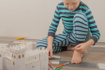 Happy boys build vintage cardboard castle and draw it with felt-tip pens. Children are happy together on holiday. Game and intensive learning of preschoolers. Shallow focus.