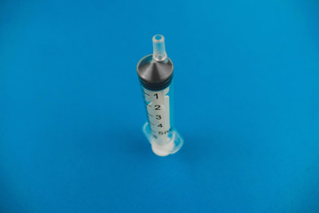 medical syringe lying on a blue background