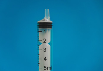 medical syringe lying on a blue background
