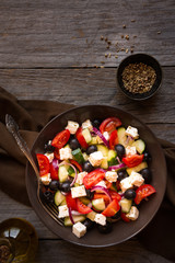 Delicious greek salad with feta cheese and olives in a brown plate