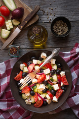 Delicious greek salad with feta cheese and olives in a brown plate