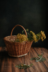 Fototapeta na wymiar Autumn composition with yellow tansy flowers in a wicker basket on a wooden background