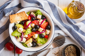 Delicious greek salad with feta cheese and olives in a white bowl