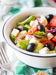 Delicious greek salad with feta cheese and olives in a white bowl