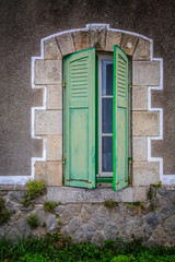 Fototapeta na wymiar shuttered window on a french farmhouse partially open closed