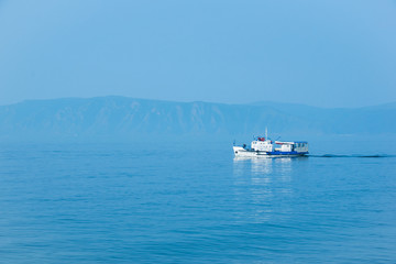 The white ship sails on lake Baikal on a Sunny day.