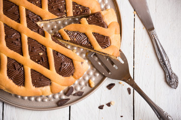 Delicious homemade chocolate cake on white wooden background