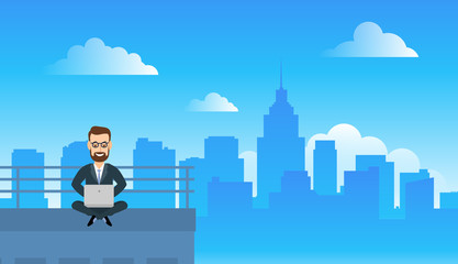 businessman sitting on the roof and using  laptop remote working concept