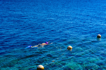 Fototapeta na wymiar Young woman snorkeling in a Red sea. Summer vacation concept