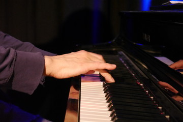 Fototapeta na wymiar Hand seitlich auf Klaviertastatur
