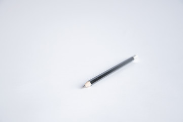 black pencil lies on the table on a white background.