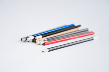 pencils of different colors scattered on a white table. On a white background.