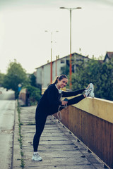 Attractive sportive young woman doing stretching exercises on the bridge