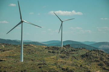 Several wind turbines over hilly landscape