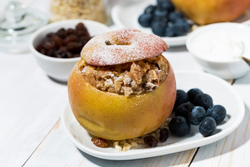 healthy breakfast. portioned oatmeal baked in apple on white table