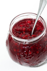 jar with sweet cowberry jam on white background, vertical top view
