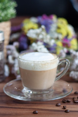 cup of coffee with cream on wooden background