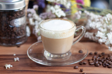 cup of coffee with cream on wooden background