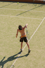 Boy playing tennis on summer holiday