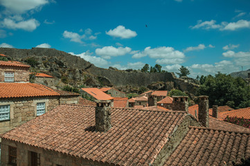 Rooftops of old houses with chimneys and large wall