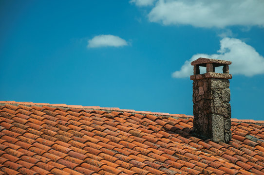 Rooftop covered by shingles and stone chimney