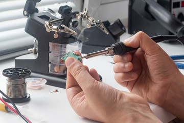 the engineer is soldering the board to restore its performance