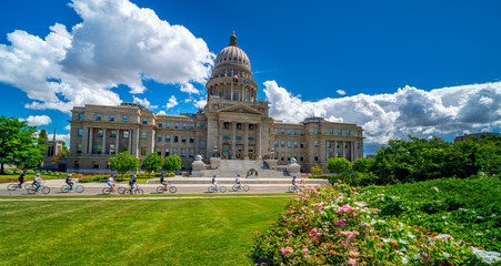 Group of bicyclers rids on a street in front of the Idaho State Capital